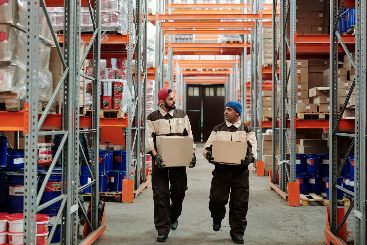 Warehouse team members handling shipping cartons in a distribution aisle
