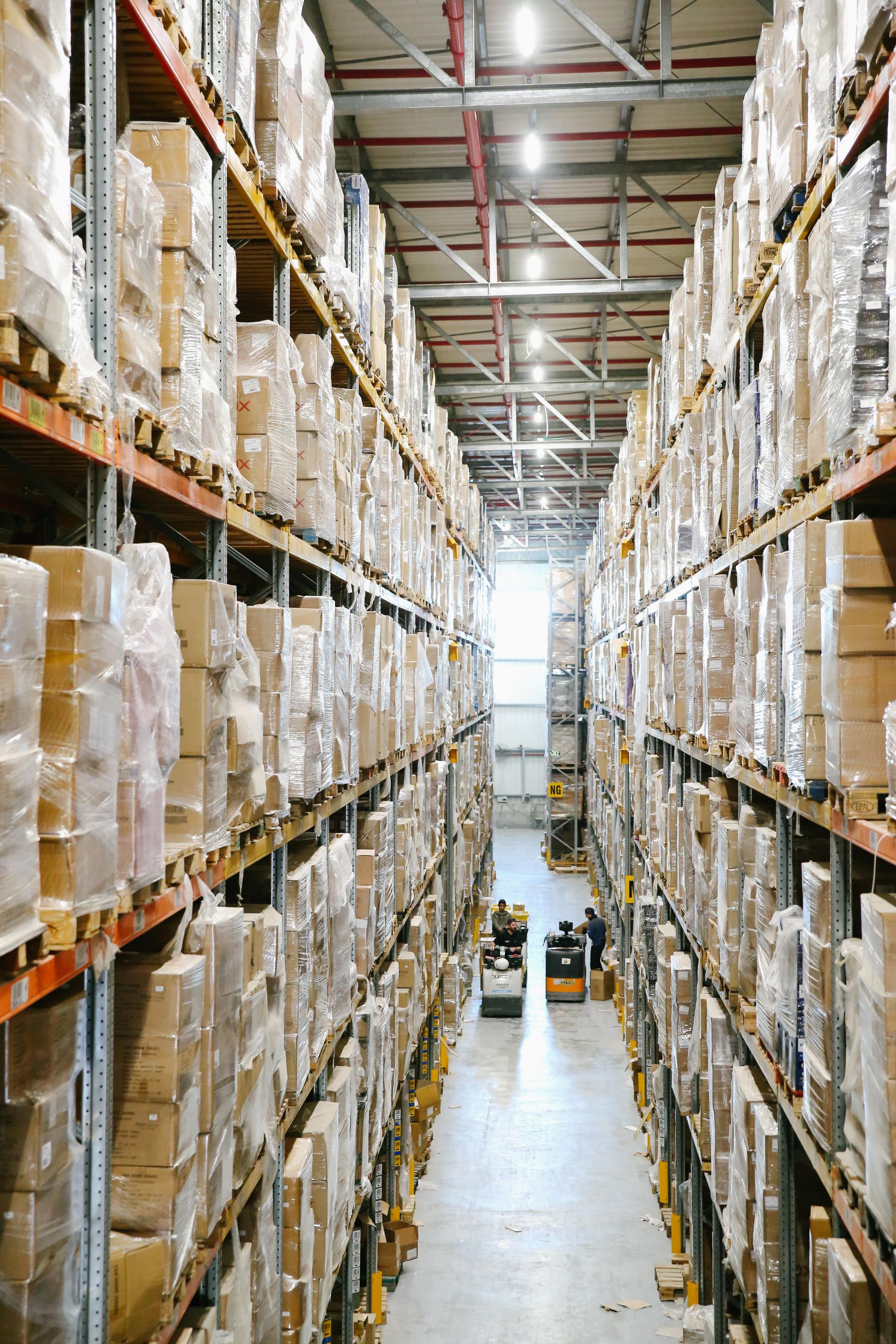 Organized warehouse aisle with shelving and shipping cartons